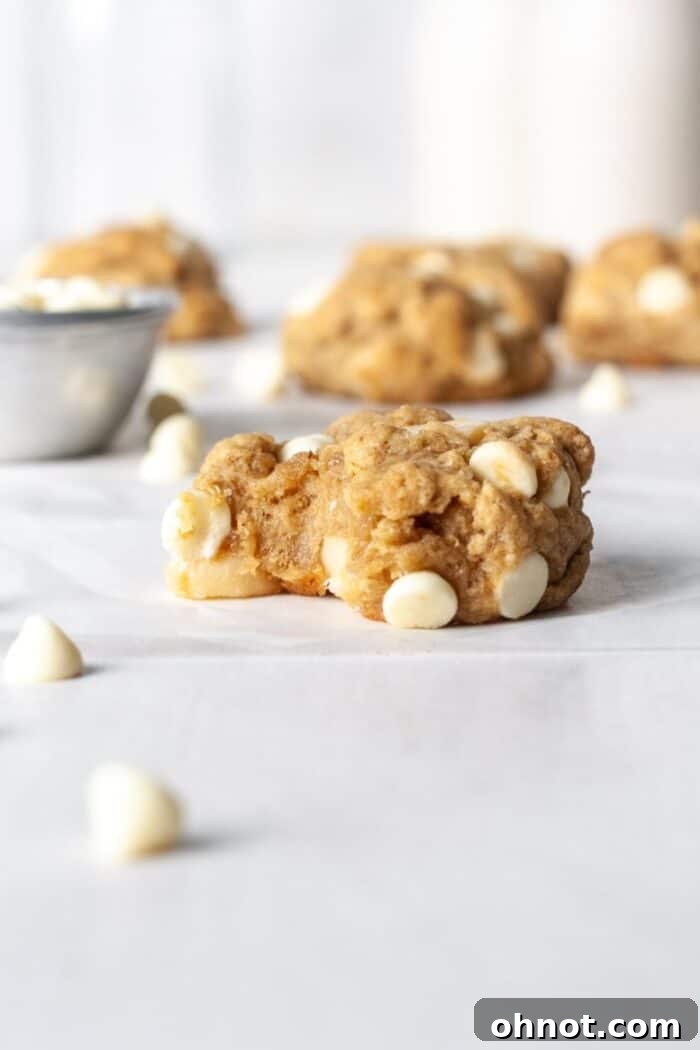 Close-up of perfectly baked vegan cookies featuring melted white chocolate chips and macadamia nuts.
