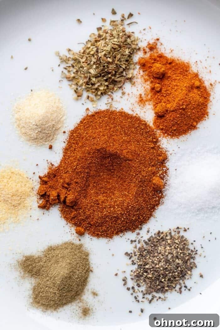 Close-up shot of gluten-free Cajun seasoning on a white plate, highlighting the vibrant colors of the spices like paprika and cayenne.
