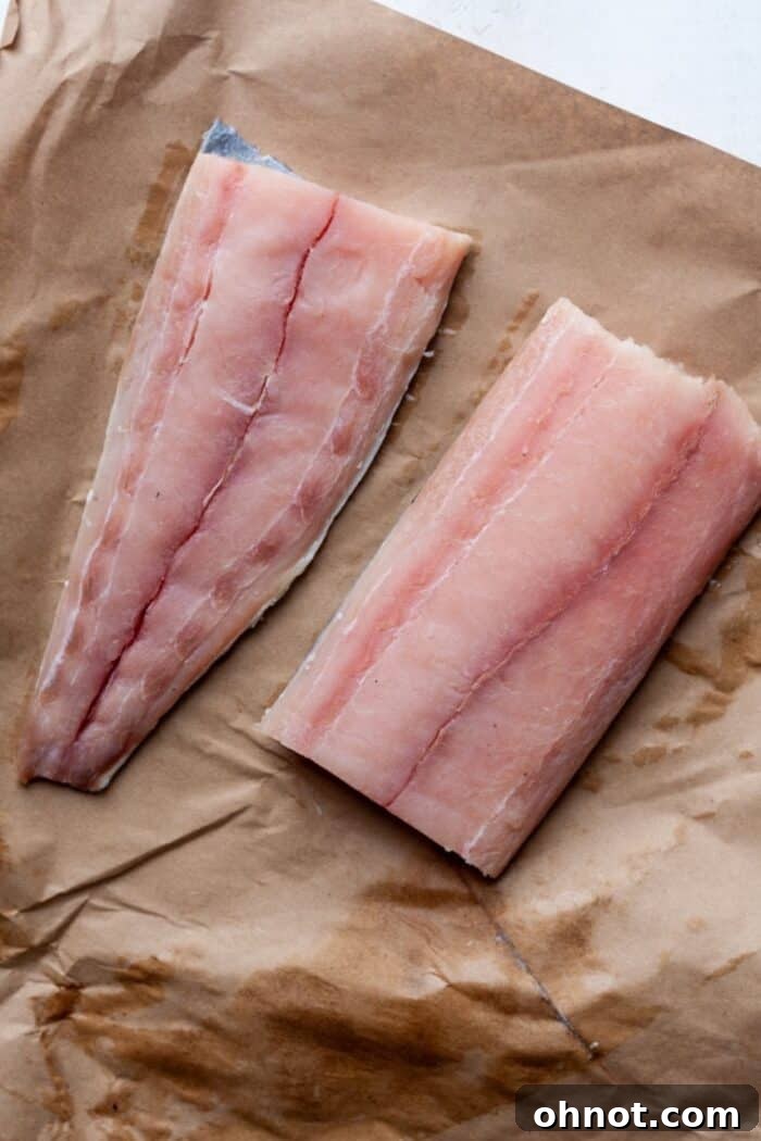 Raw mahi mahi fillets on a cutting board, prepared for seasoning and cooking.