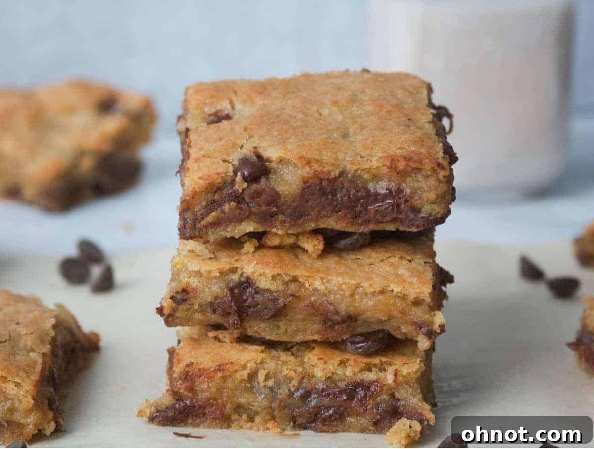 Gooey, crinkly-top blonde brownies with dark chocolate chips, perfectly sliced and ready to eat, suggesting a delightful, healthy dessert.