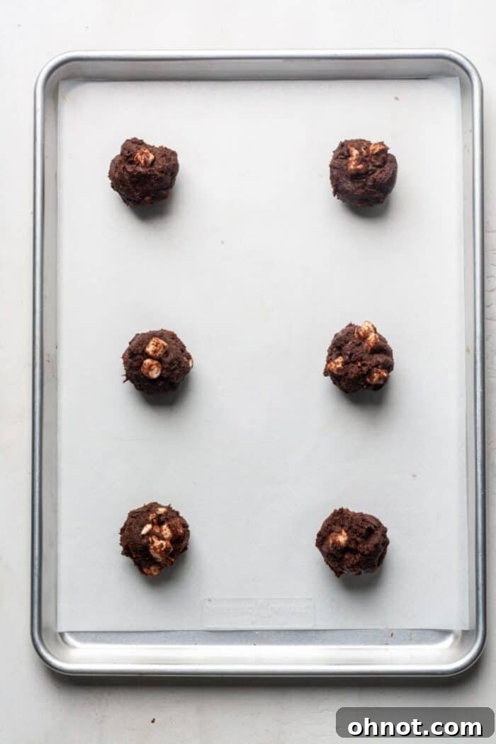 Raw chocolate cookie dough balls with marshmallows on a baking sheet