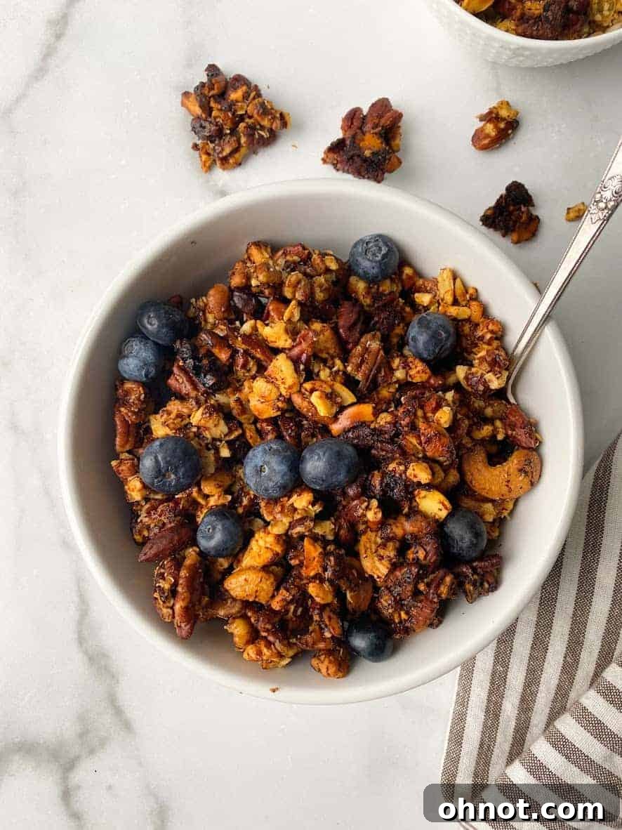 A bowl of homemade granola with fresh berries and coconut yogurt