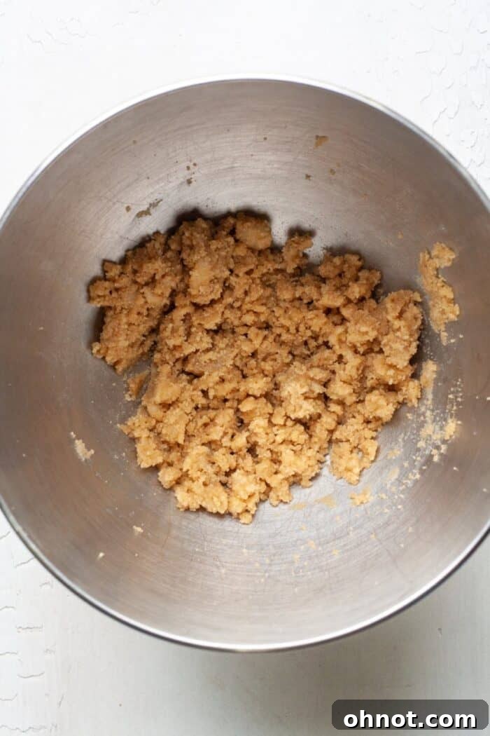 Creamed coconut oil and brown sugar mixture in a mixing bowl, ready for the next ingredients.