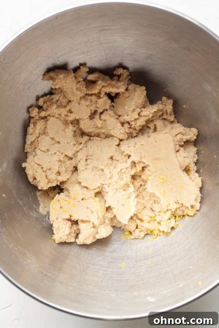 Thick, ready-to-bake vegan lemon cookie dough in a mixing bowl.