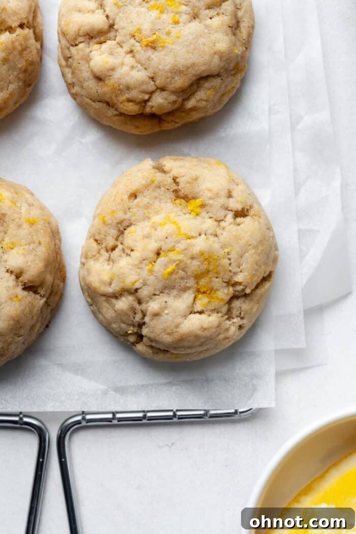 Freshly baked lemon cookies cooling on a wire rack after being removed from the oven.
