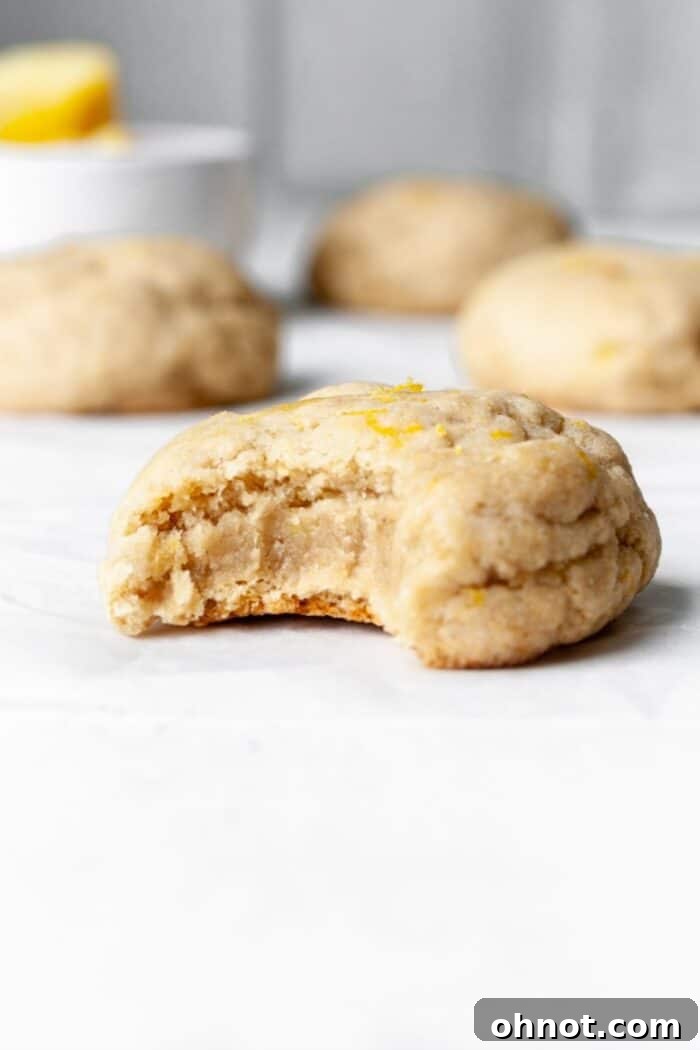 Close-up of thick, chewy vegan lemon cookies, showcasing their golden edges and soft centers.