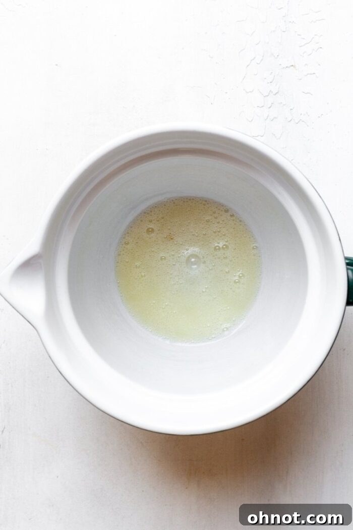 Whisked egg white in bowl, prepared to bind the delicious Whole30 granola ingredients