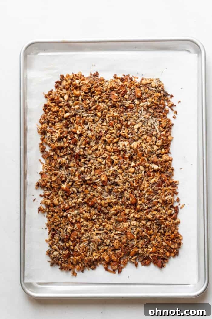Paleo granola baking on a pan, achieving golden brown edges and a crispy texture