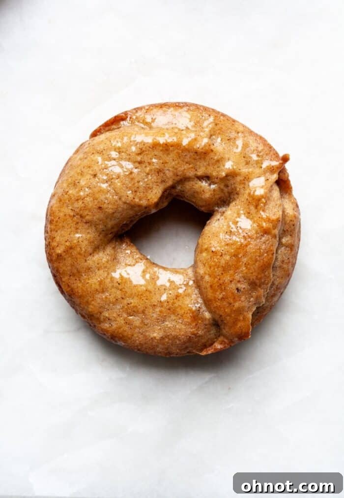 A freshly baked donut being brushed generously with melted butter