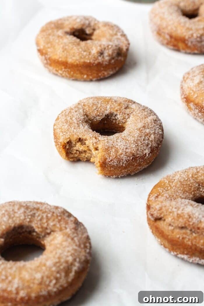 A group of perfectly baked gluten-free donuts arranged neatly on a wire rack