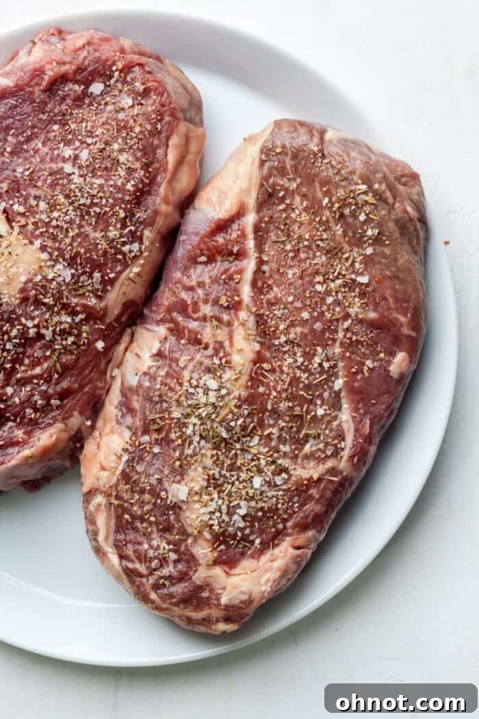 Ribeye steak perfectly seasoned with dry rub on a plate, ready for the air fryer
