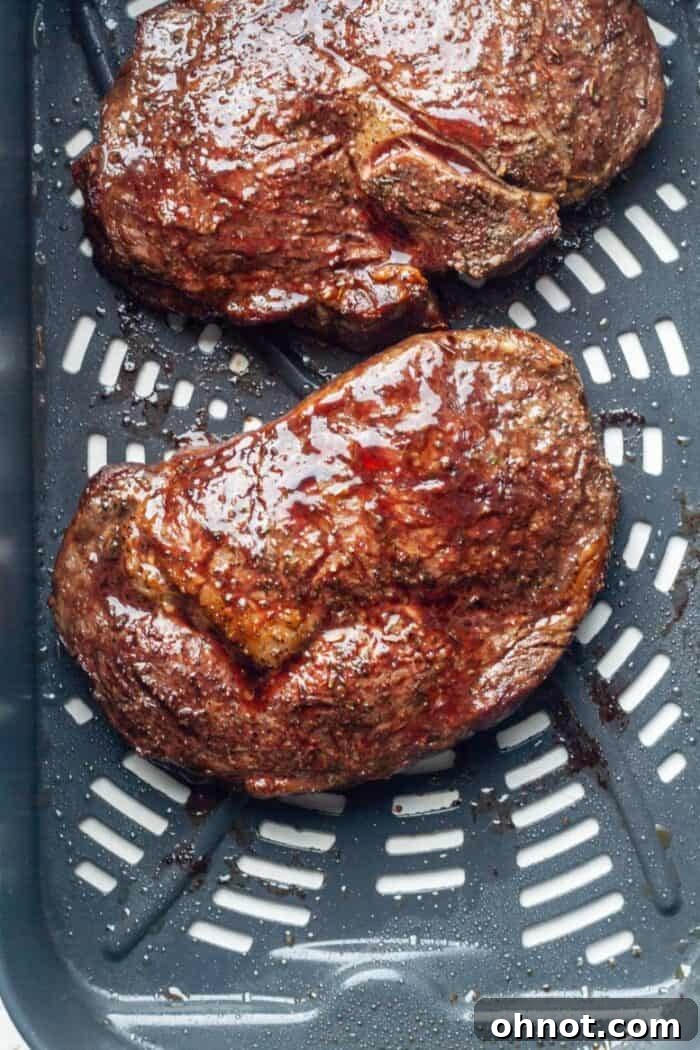 Air frying ribeye steak in progress inside the air fryer, creating a perfect crust