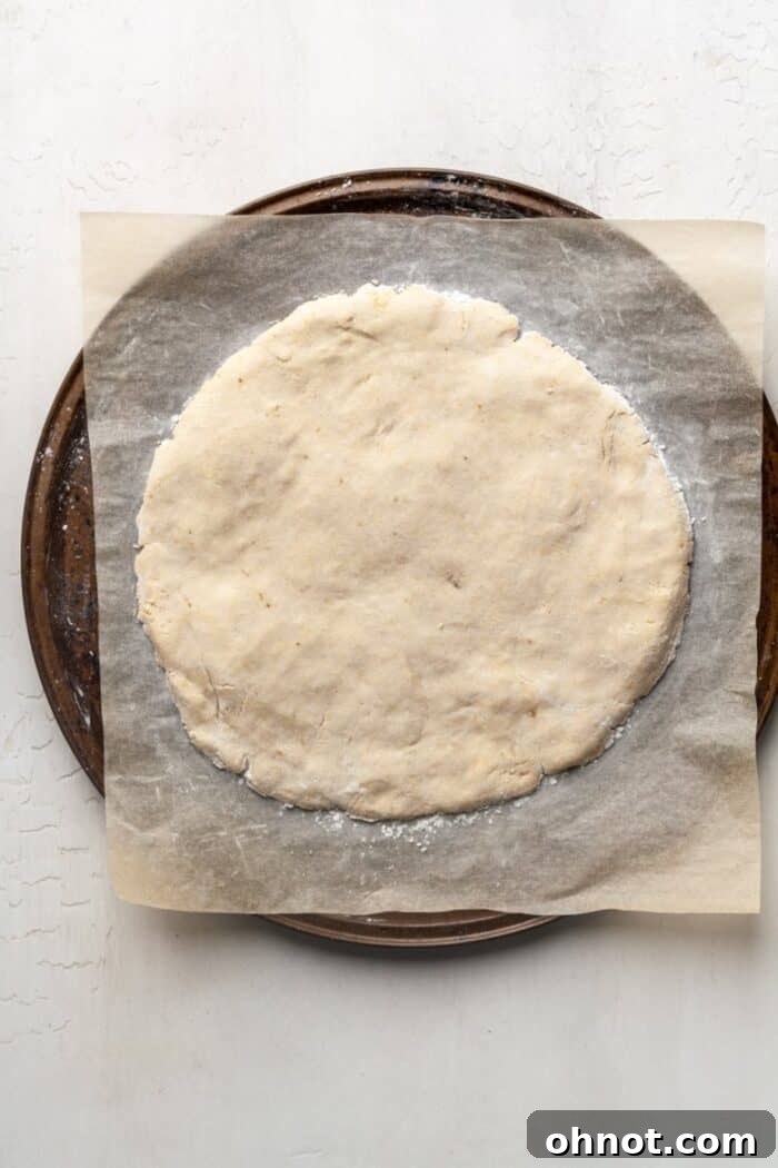 A pre-baked Paleo pizza crust resting on a baking pan, golden brown and ready for toppings.