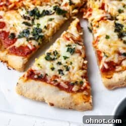 Paleo pizza crust with melted dairy-free cheese and fresh basil.