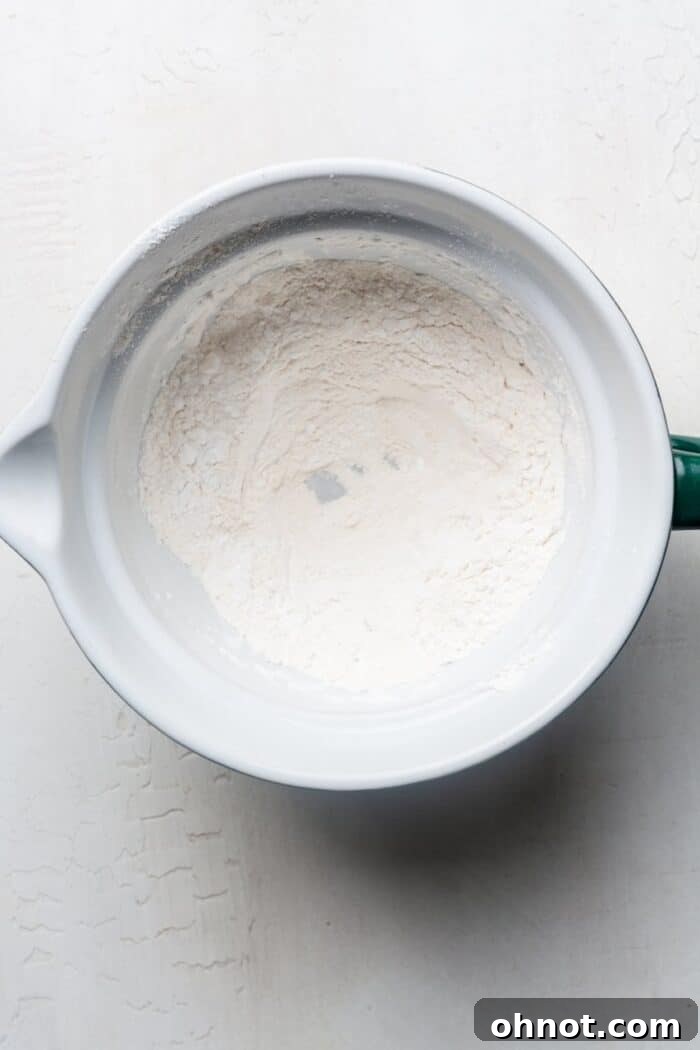 A bowl filled with white cassava flour, ready for mixing to create a healthy pizza crust.