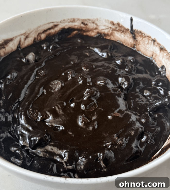 Dark cocoa brownie batter in a bowl.