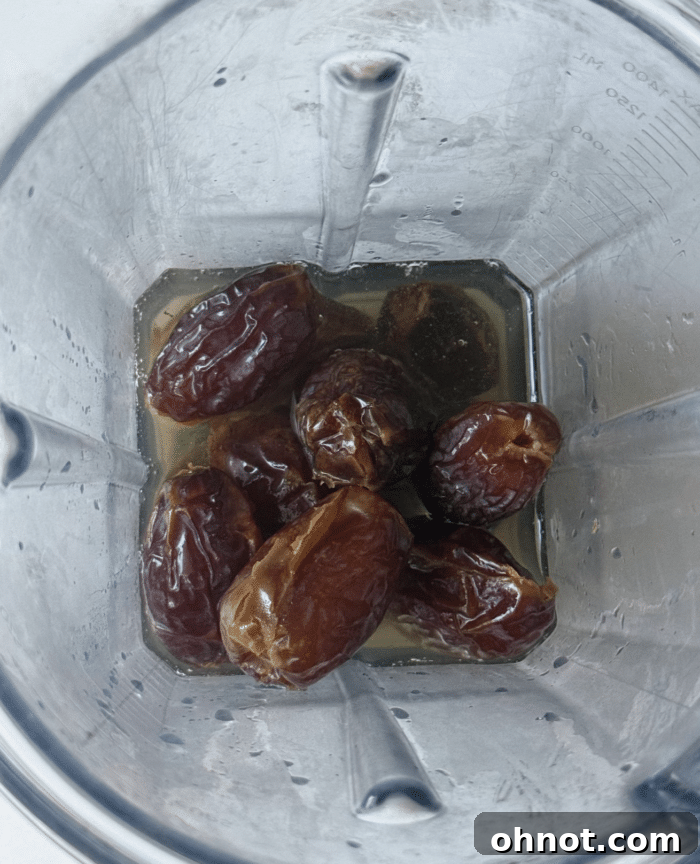 Dates and water being blended into a smooth paste.