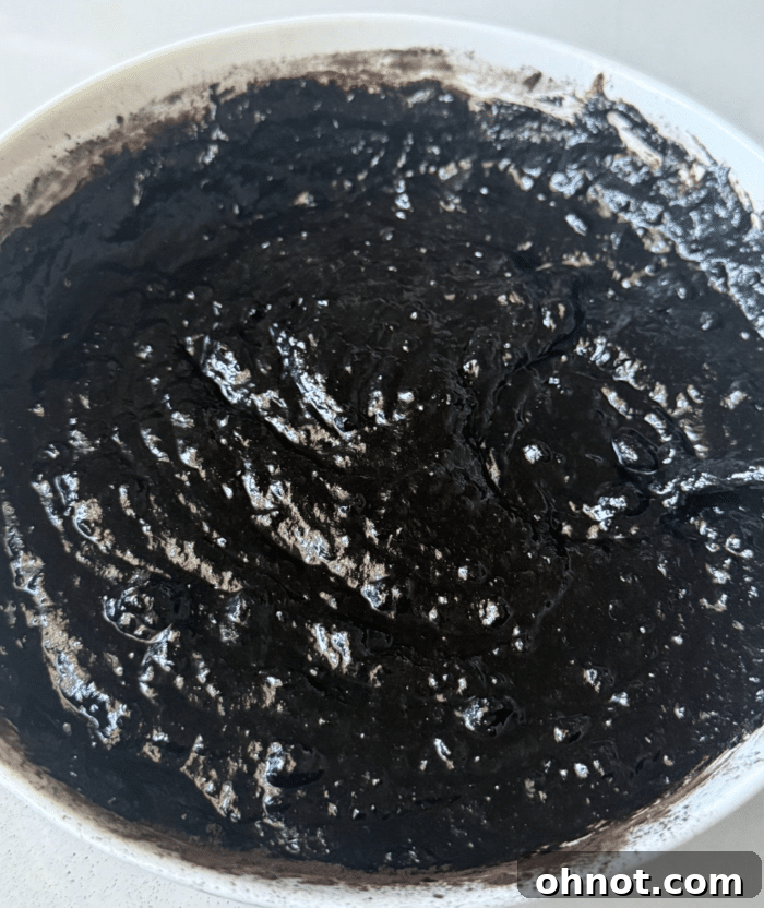 Rich, dark date brownie batter in a mixing bowl.
