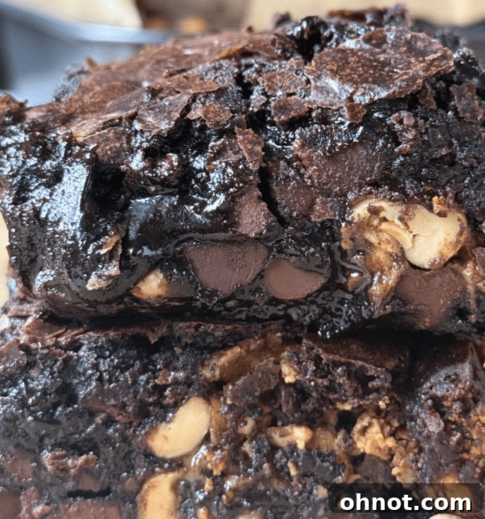 An inviting close-up of a stack of Snickers brownies, showing the rich texture and layers.