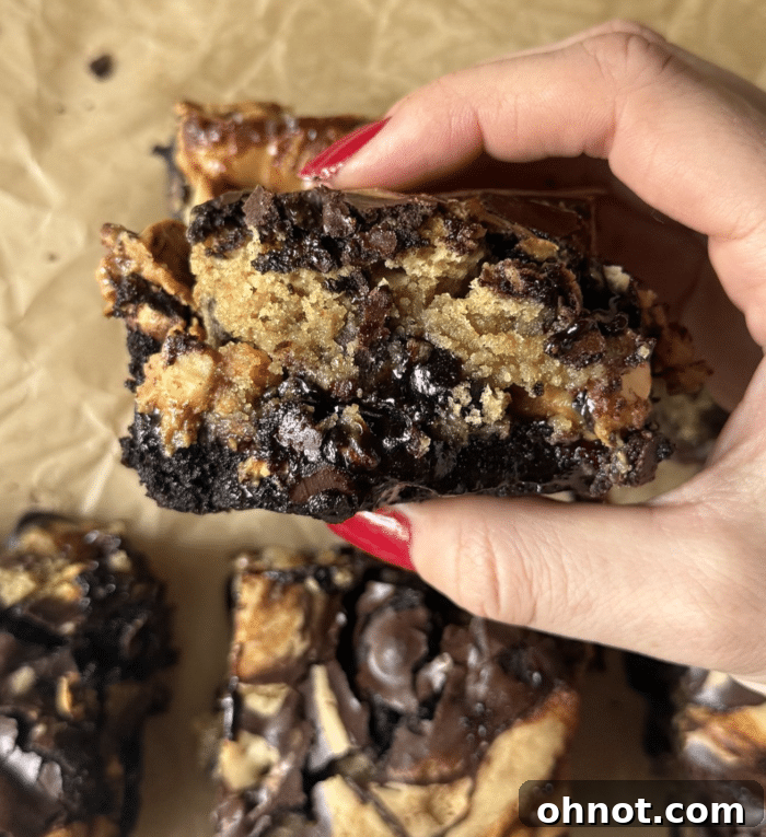 A hand holding Snickers bars, suggesting an optional addition for the Snickers Brookies recipe.