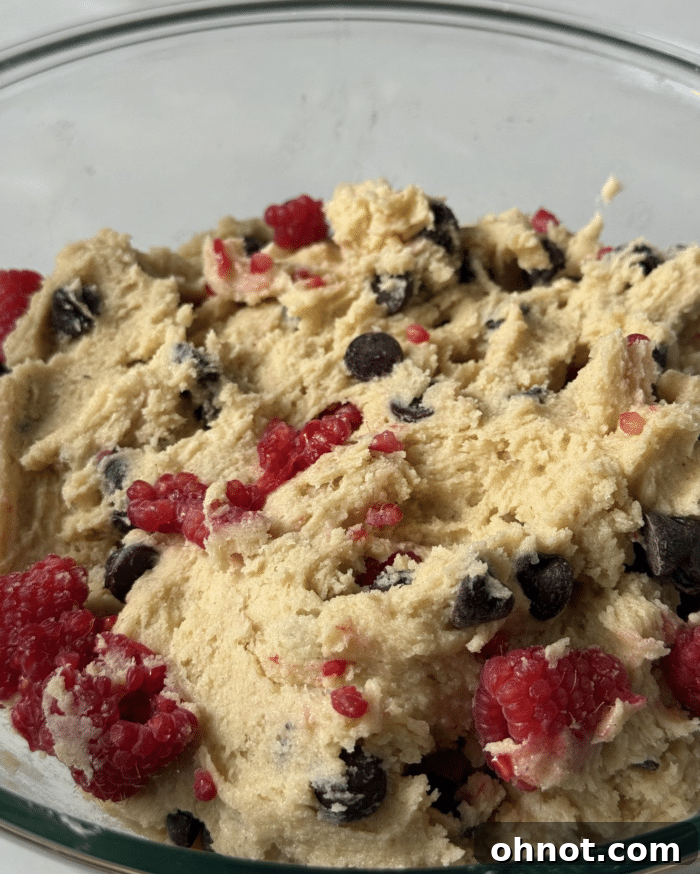 Close-up of unbaked berry cookie dough on a parchment-lined baking sheet, ready for chilling.