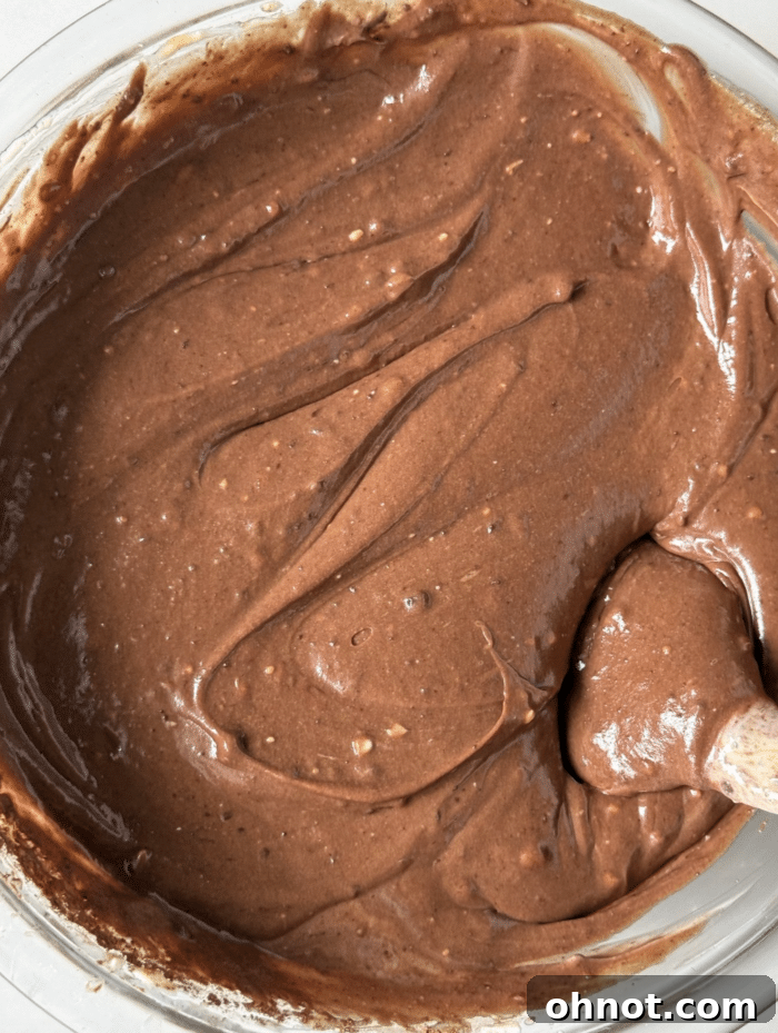 Rich, dark chocolate cheesecake filling in a mixing bowl, ready to be poured over the crust.