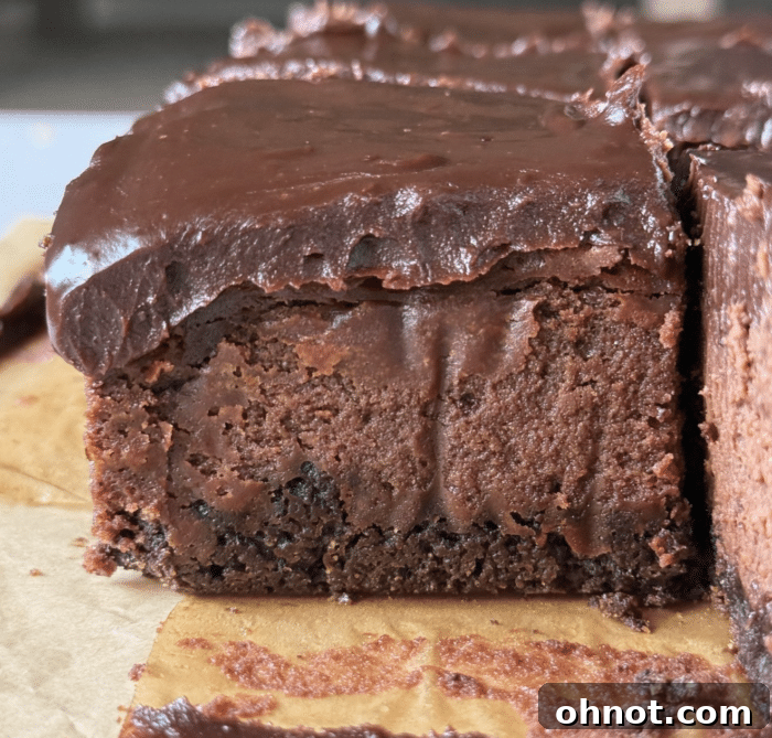 Close-up of triple chocolate bars with a rich ganache topping, showcasing the indulgent layers.