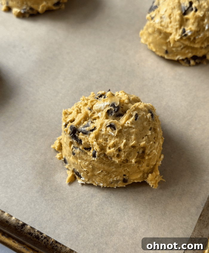 Scoops of sweet potato cookie dough on parchment paper.