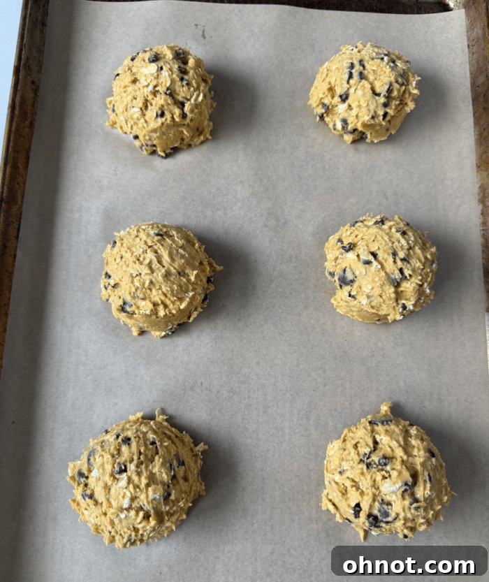 Uniform scoops of orange cookie dough before baking.