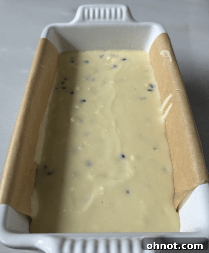 The creamy cheesecake mixture being added on top of the banana bread batter.