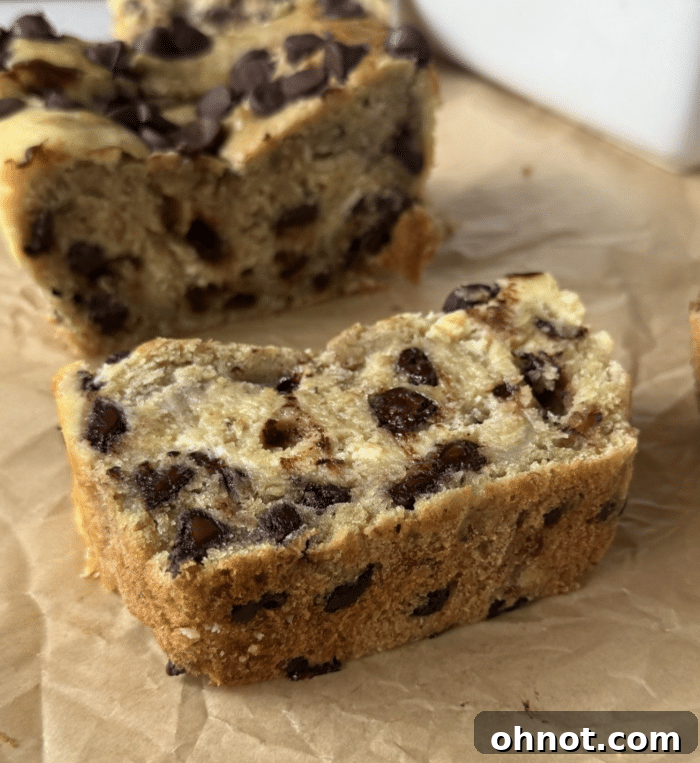 A thick, inviting slice of cheesecake banana bread, showing the moist crumb and creamy swirl.