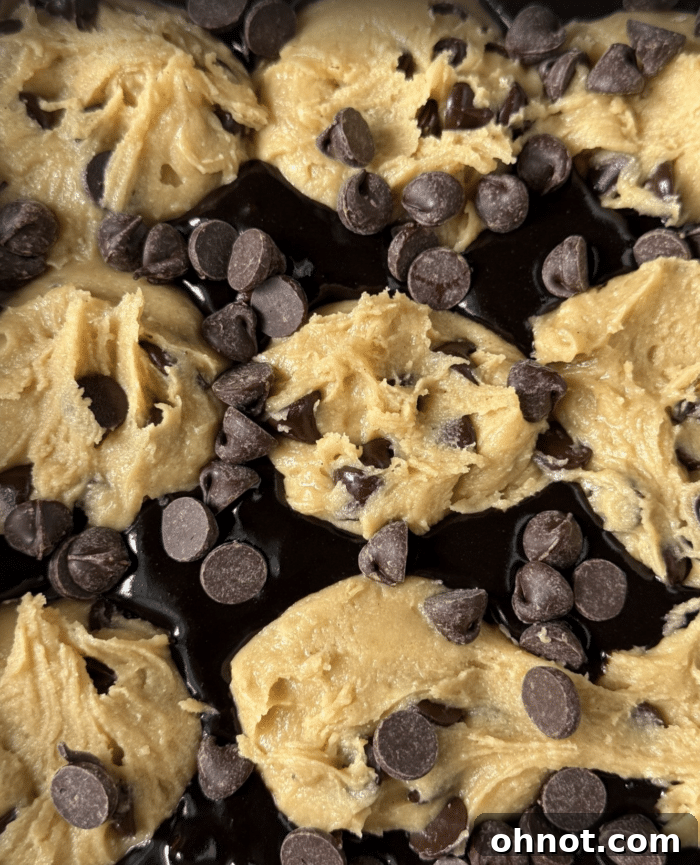 Close-up of raw cookie dough generously sprinkled with extra chocolate chips before baking.